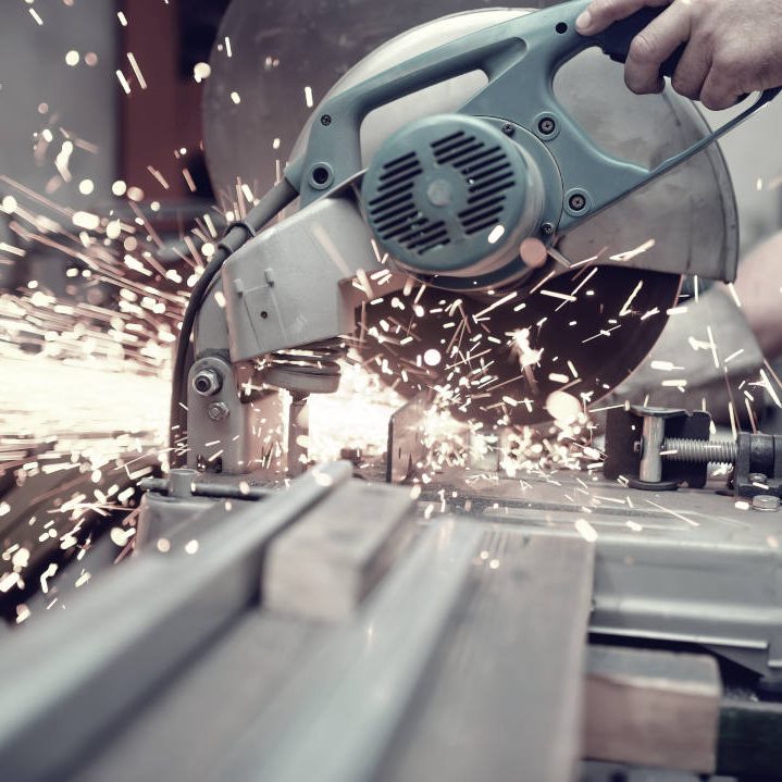A metal cutting saw throwing sparks in a workshop